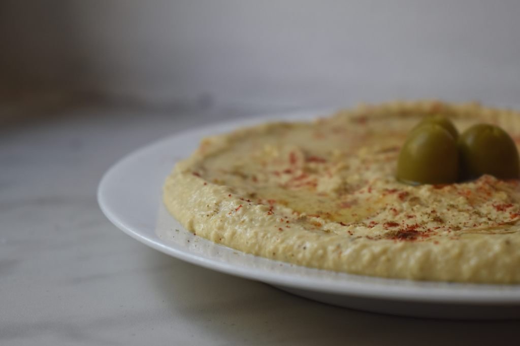 Hummus on a plate with olive